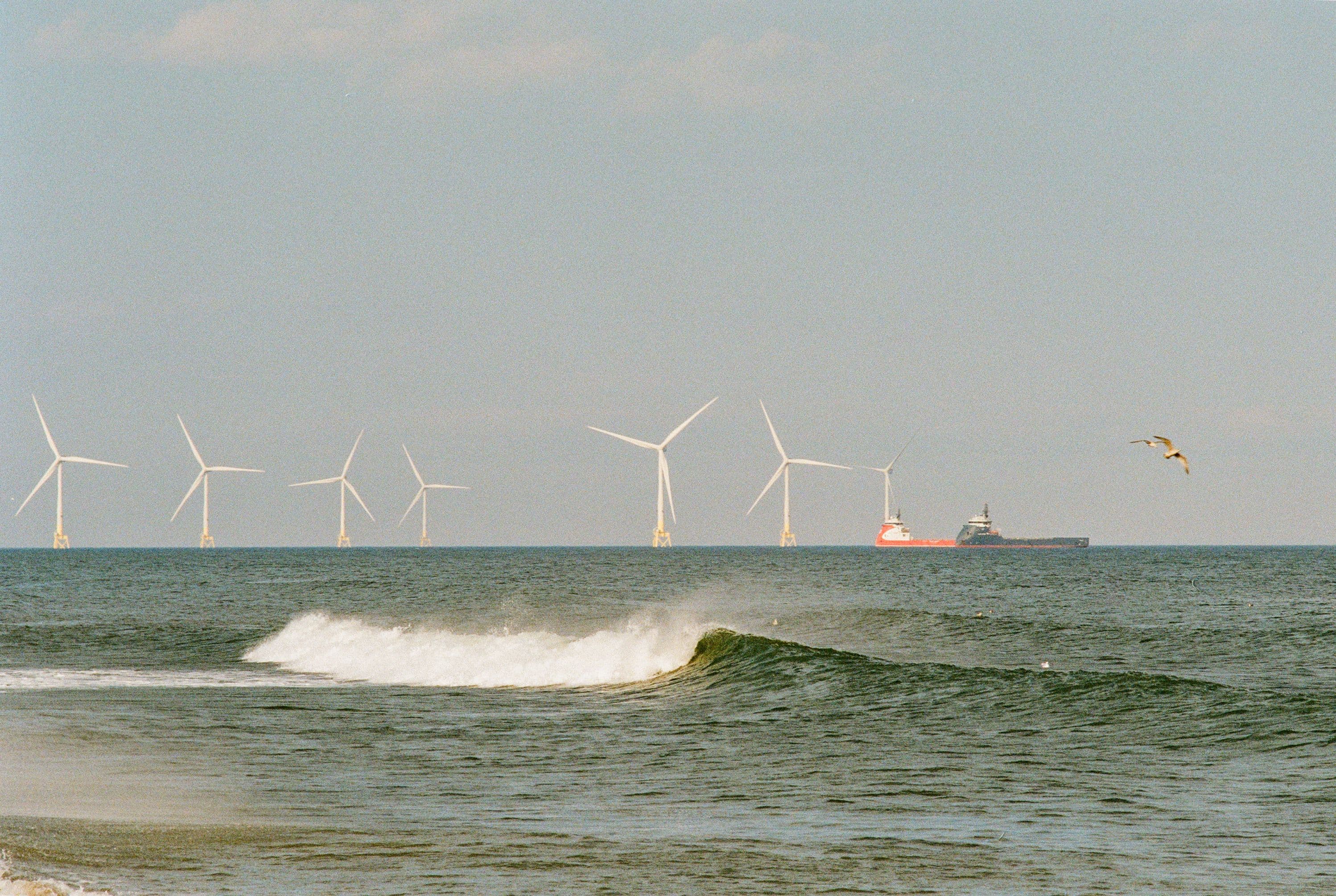 Offshore wind farm and a support vessel on the horizon